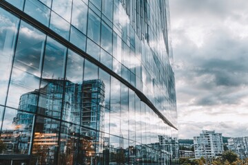 Modern glass skyscraper reflecting cityscapes