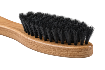 Close-up of a wooden-handled brush with black bristles.  The brush head is oval-shaped, and the handle is light brown