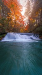 Fototapeta premium Cascading Waterfall in Autumn Woods with Teal Water