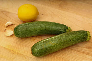 Garlic, Lemon, and Zucchini on Wooden Cutting Board