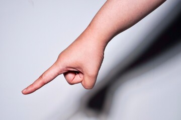 Hand pointing on something to down direction gesture pose isolated on horizontal plain background.