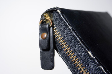 Close up wallet zipper handle isolated on horizontal white background.