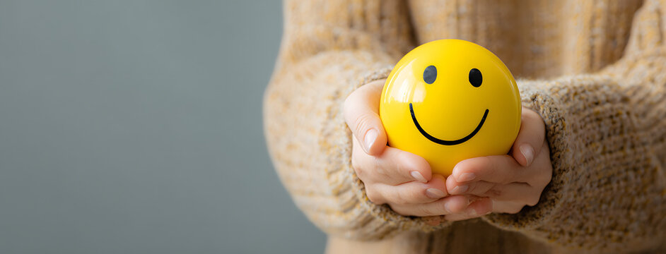 Woman hand holding happy smile sphere, Positive thinking, Mental health assessment , World mental health day concept - Powered by Adobe