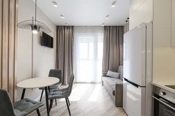 Cozy living room with a sectional sofa, armchair, wooden floor, and built-in shelving unit. Simple...