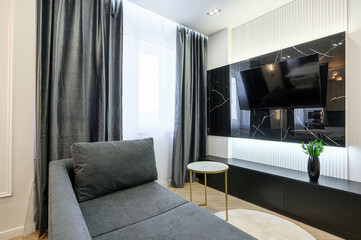 Modern living room with gray sofa, black marble TV wall, and elegant decor