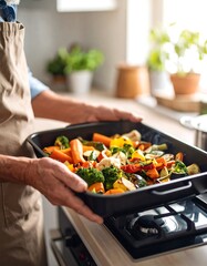 Person holding a baking sheet with roasted vegetables