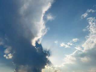 Dramatic cloud formation with sunlight breaking through, creating a stunning atmospheric display