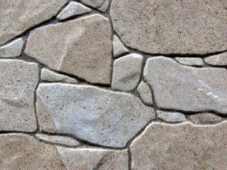 Cobblestone refers to naturally rounded stones, typically used for paving roads, streets and buildings. They are characterized by their irregular shapes and sizes, creating a rustic appearance.