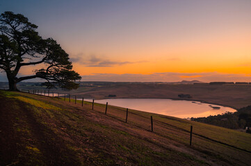Scenic view of sunset over the farm land by the lake, Camperdown, Victoria, Australia
