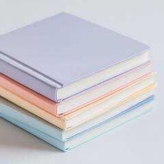Stacked arrangement of hardcover books with soft pastel colored covers on a plain white background  Minimalist clean and organized publication or education concept