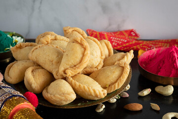 Gujhiya, Indian fried sweet with dry fruits and fancy decorative background