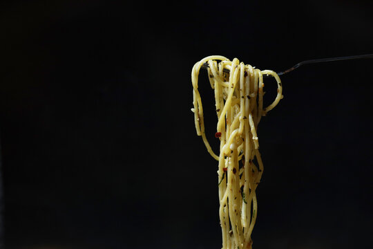 Spaghetti pasta aglio olio with cherry tomato olives on white platter
