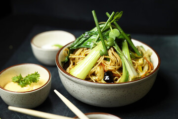 Noodles in bowl with chopsticks soya sauce and spring onions 
