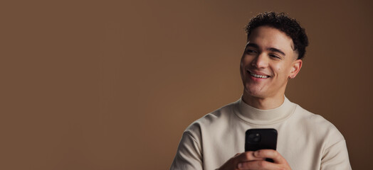 Man, phone and happy with thinking in studio with mockup space, decision and online dating on...