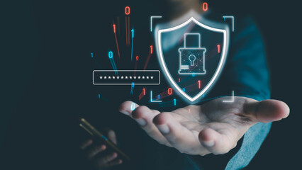 Businessman holding a phone presents a holographic shield icon for cybersecurity, data protection, and password authentication on a dark background.