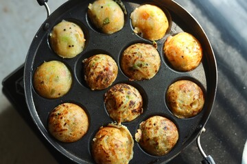 Appam or Mixed dal or Rava Appe South Indian dish preparation on iron pan