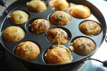Appam or Mixed dal or Rava Appe South Indian dish preparation on iron pan