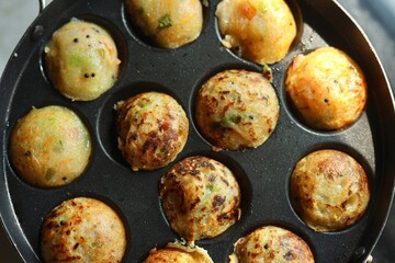 Appam or Mixed dal or Rava Appe South Indian dish preparation on iron pan
