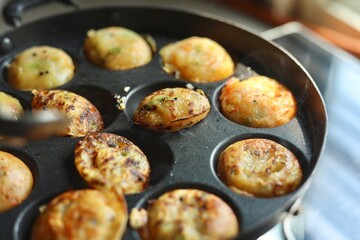 Appam or Mixed dal or Rava Appe South Indian dish preparation on iron pan