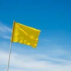 Bright Yellow Flag Waving Against a Clear Blue Sky on a Sunny Day