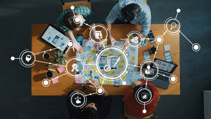 Collaborative Workspace with Team Members Engaging in Project Planning and Brainstorming Session Over Table Surrounded by Digital Connectivity Icons. Amity