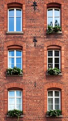 Fototapeta premium Old brick building with windows and flowers