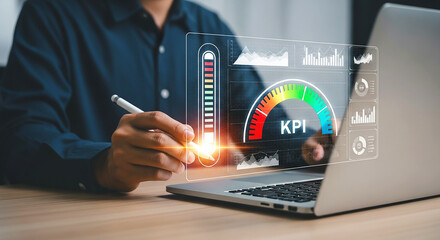 Person using a stylus on a laptop displaying a kpi dashboard with charts and a gauge indicator