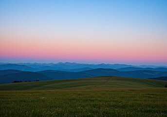 Mountain meadow at dawn;  pink-blue sunrise over distant hills.  Use nature, landscape