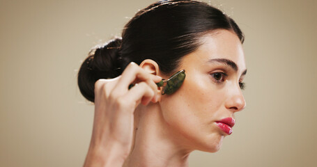 Beauty, cosmetics and woman with jade roller on face for lymphatic drainage, skin glow and...