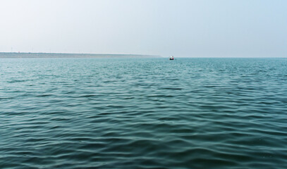 Obraz premium Serene Ocean View With Calm Waves and Distant Boat Under Clear Sky