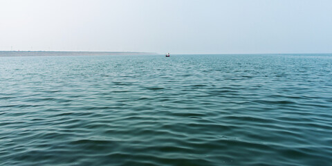 Serene Ocean View With Calm Waves and Distant Boat Under Clear Sky