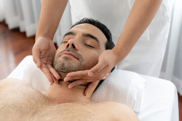 Caucasian man enjoying relaxing anti-stress head massage and pampering facial beauty skin...