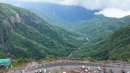 Lush green valley between mountains surrounded with clouds
