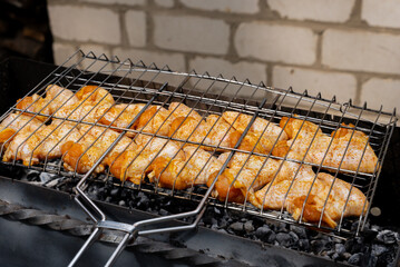 BBQ picnic time Roasted chicken legs and wings on grill. Grilling meat on outdoor grill grid tasty...