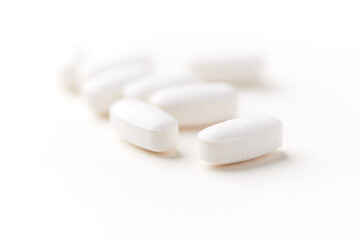 Creatine tablets on paper background. Soft focus. Close up. Copy space.	