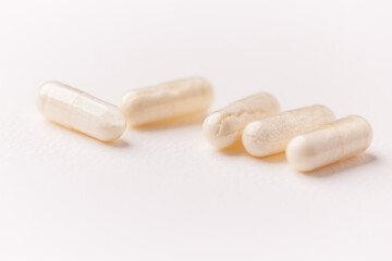 Coenzyme Q10 capsules. Antioxidants. Concept for a healthy dietary supplementation. Bright paper background. Soft focus. Close up. Copy space.	