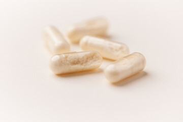 Coenzyme Q10 capsules. Antioxidants. Concept for a healthy dietary supplementation. Bright paper background. Soft focus. Close up. Copy space.	