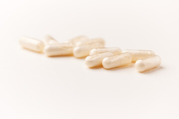 Coenzyme Q10 capsules. Antioxidants. Concept for a healthy dietary supplementation. Bright paper background. Soft focus. Close up. Copy space.	