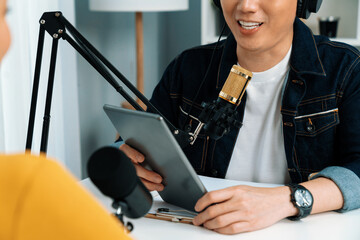 Focusing on radio influencer host holding tablet wearing headphones interview woman speaker social...