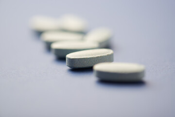 Multivitamin tablets on dark paper background. Soft focus. Close up. Copy space	