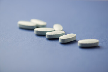 Multivitamin tablets on dark paper background. Soft focus. Close up. Copy space