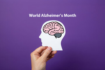 Hand holding paper brain cutout for world alzheimer s month awareness