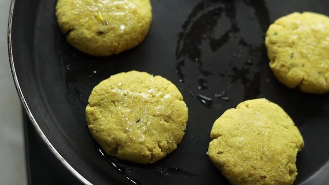 Tikki an indian street food being fried in oil on a pan