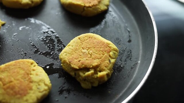 Tikki an indian street food being fried in oil on a pan