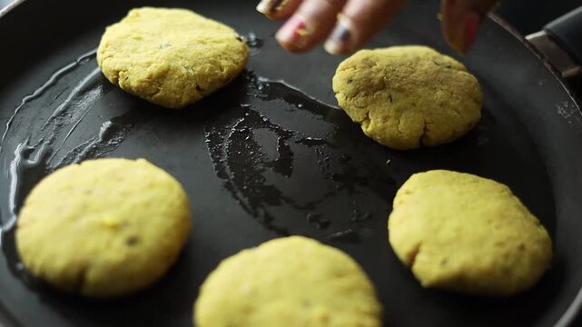 Tikki an indian street food being fried in oil on a pan