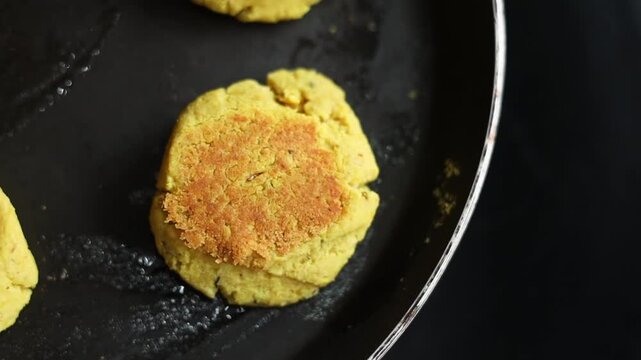Tikki an indian street food being fried in oil on a pan
