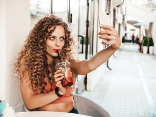 Young beautiful smiling hipster woman with afro curls hairstyle.Female in summer trendy clothes...