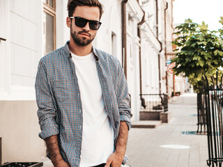 Portrait of handsome confident stylish hipster lambersexual model.Man dressed in white T-shirt....