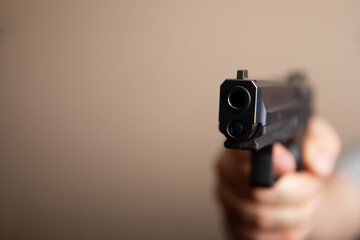 A person is holding a gun and pointing it at the camera