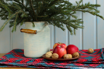 Christmas still life with apples, walnuts and spruce branches in milk can